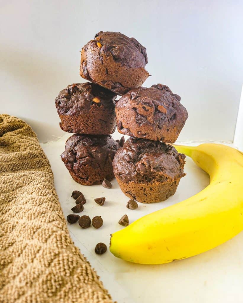 chocolate banana muffins stacked on top each other.
