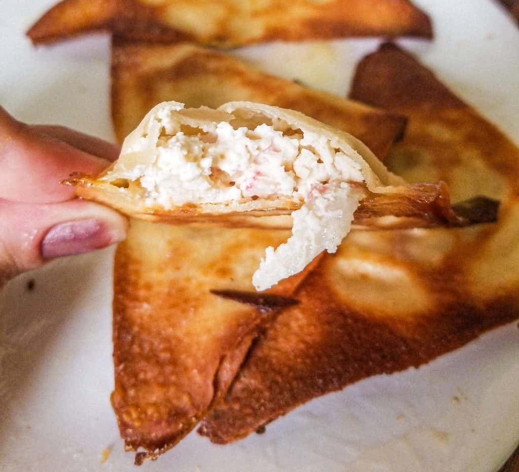 inside of crab rangoon with someone holding it. 