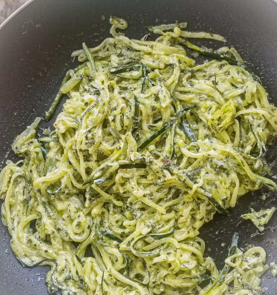 creamy pesto zoodles in a black skillet. 