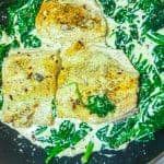 salmon with spinach cream sauce in a pan