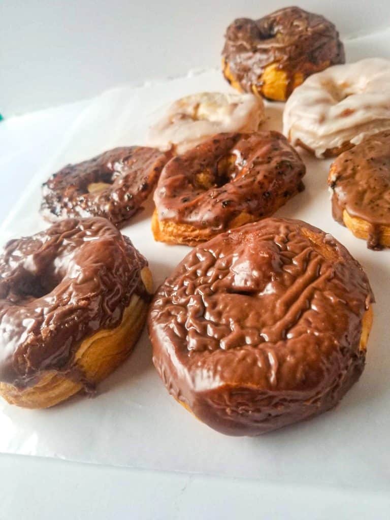 air fryer donuts from biscuits with frosting under waxed paper.