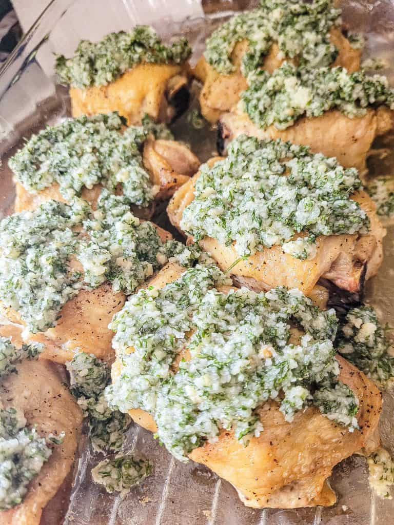 garlic parmesan chicken thighs in a glass baking dish.