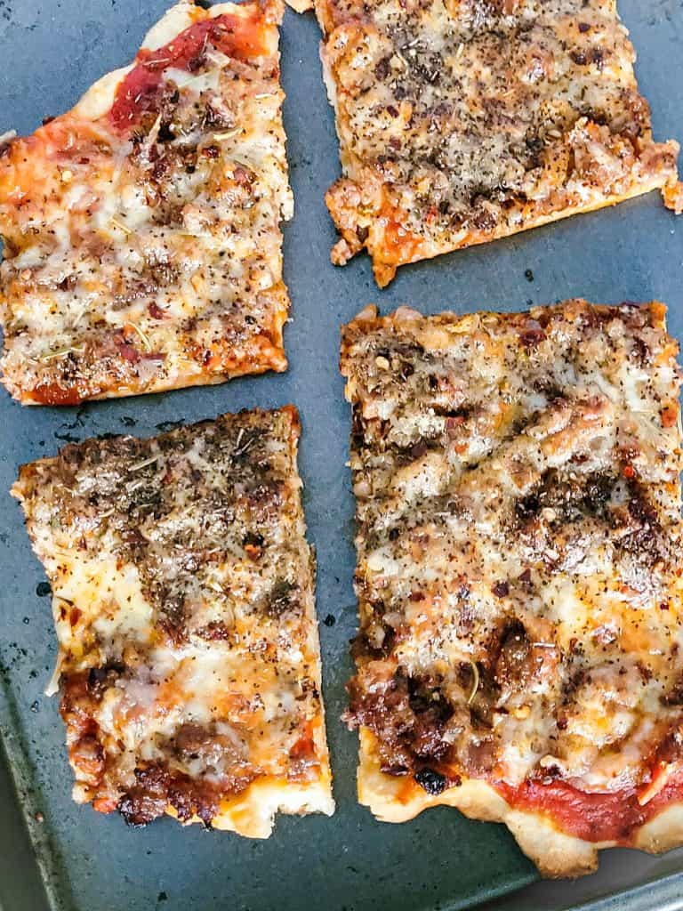 school lunch pizza on a gray baking sheet.