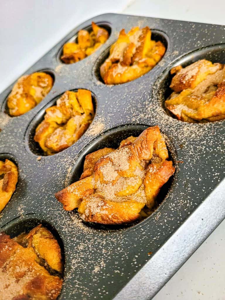 french toast muffins in pan with cinnamon sugar on top.