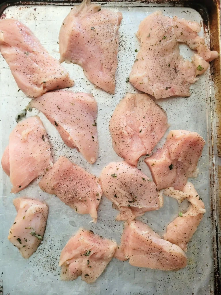 seasoned chicken on a baking sheet.