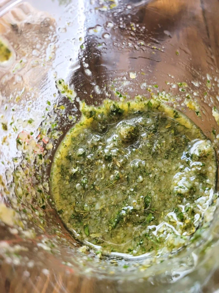 Garlic parmesan sauce in a glass cup.