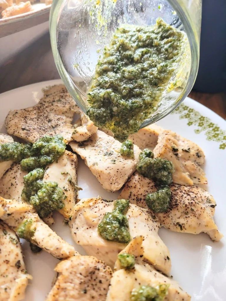 Garlic parmesan sauce being poured on chicken.