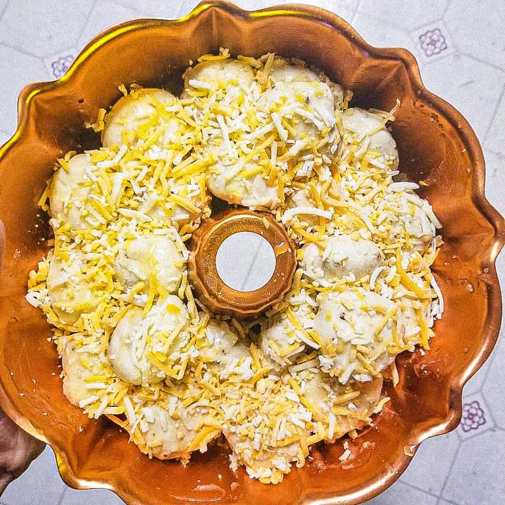 unbaked stuffed garlic bread in an orange bundt pan.