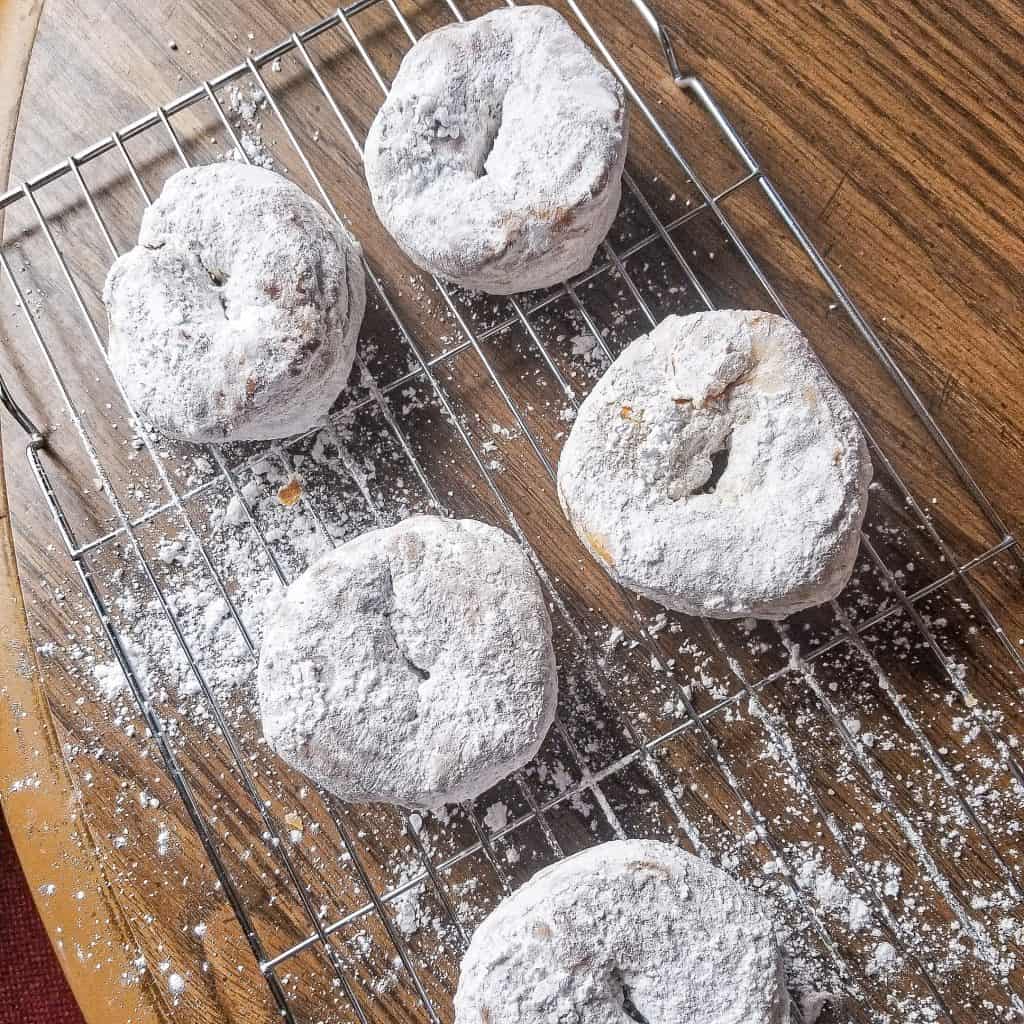 air fryer donuts on cooling rack with powdered sugar.