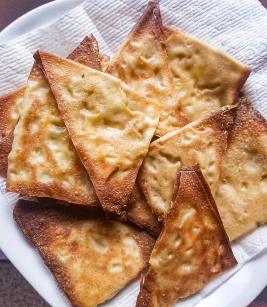 baked crab rangoons on a plate with paper towels under. 