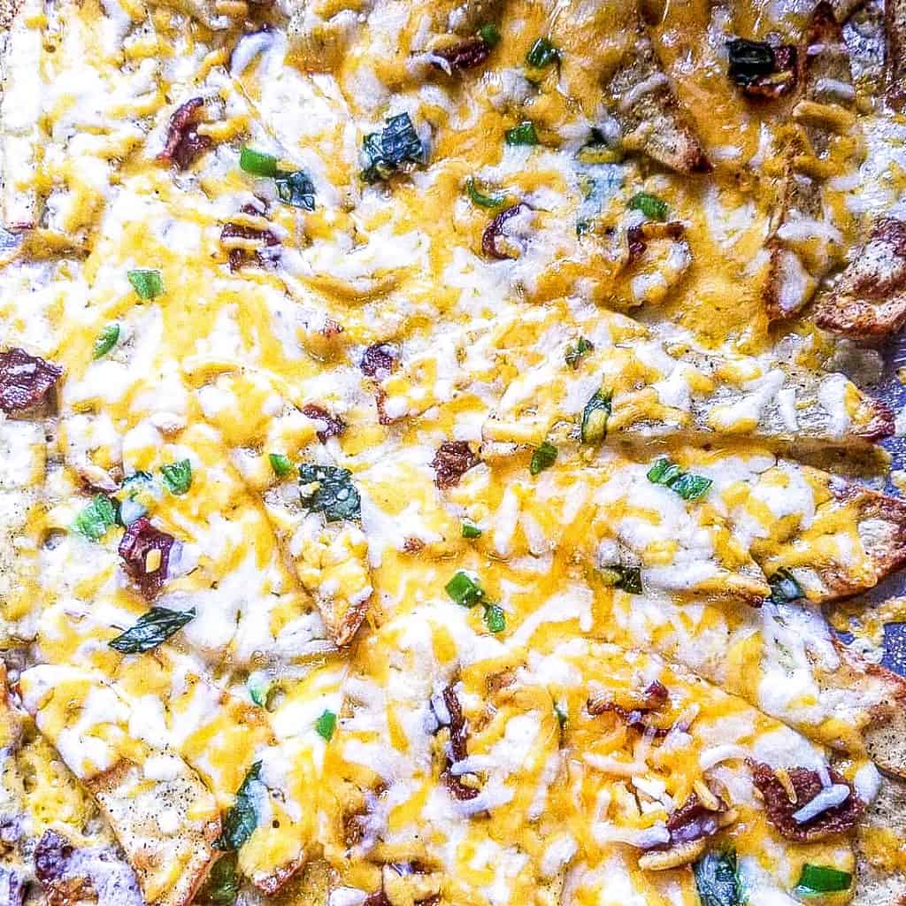 loaded fries with cheese on a pan from top view. 
