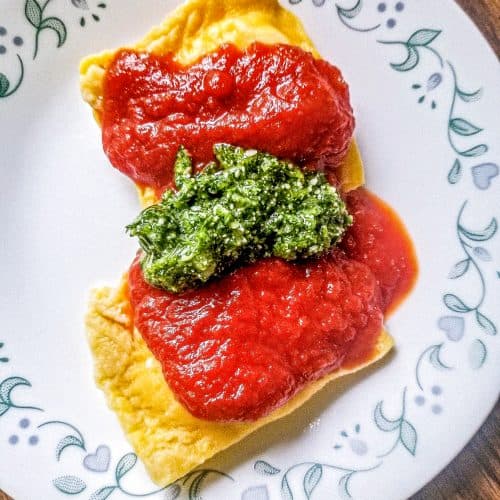 spinach and artichoke ravioli with sauce on top