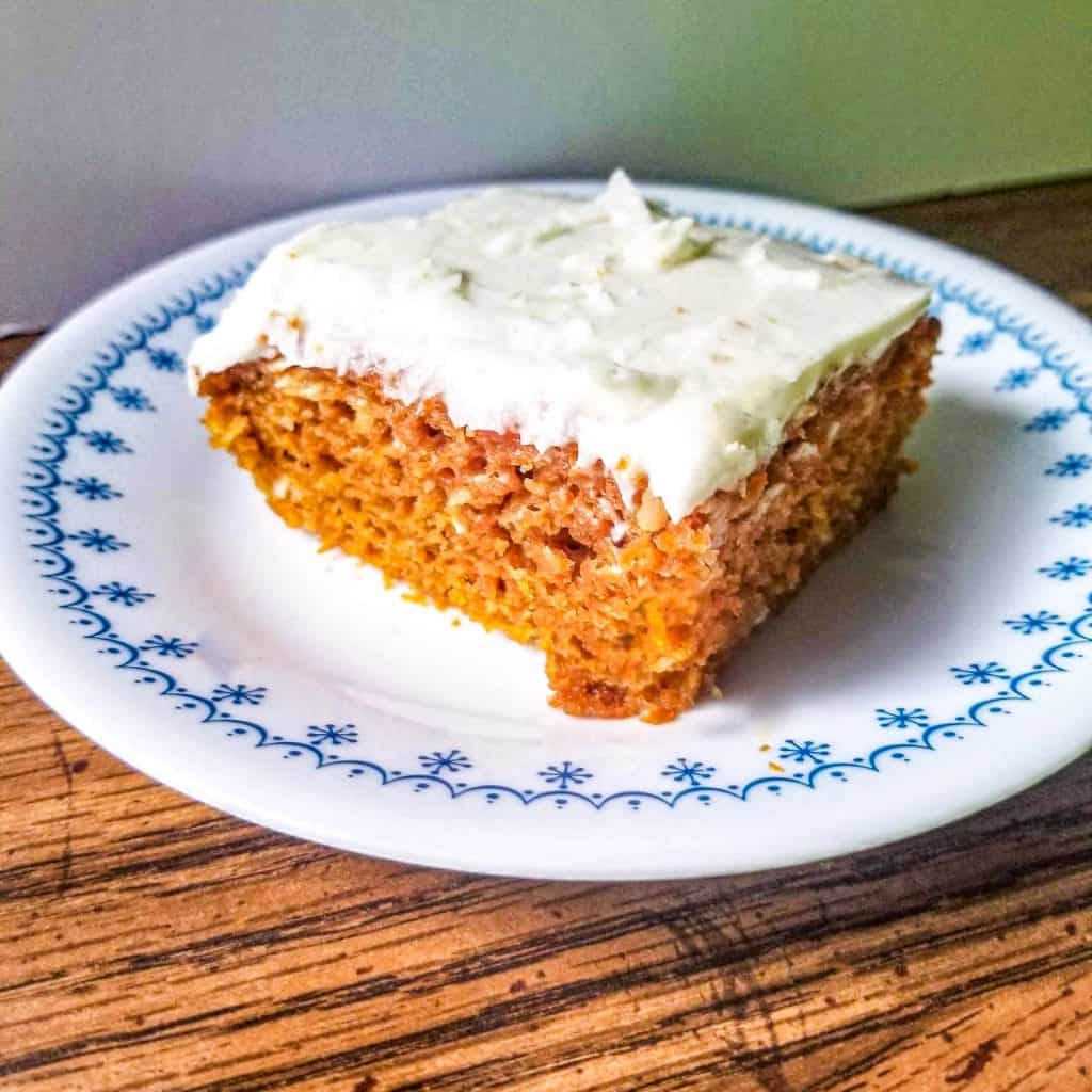 carrot cake with frosting on a plate.