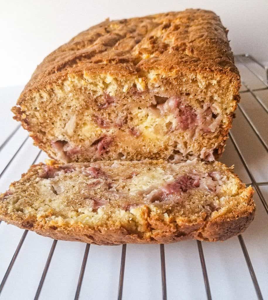 strawberry cream cheese bread loaf with one slice cut on a wire rack. 