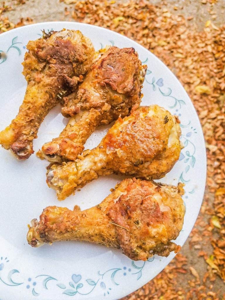 air fryer fried chicken on a plate with leaves in the background.