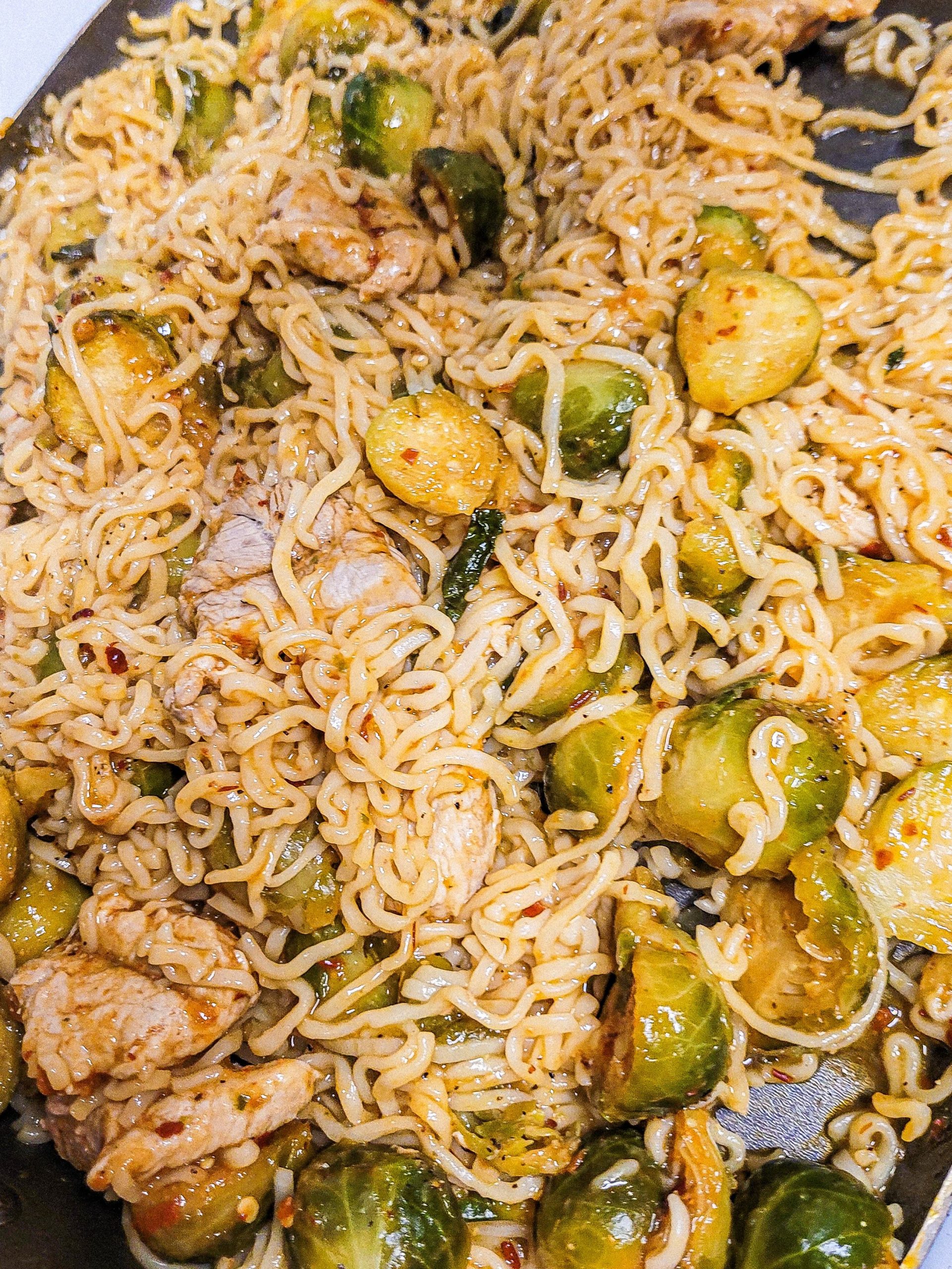 side angle of pan fried ramen noodles in a skillet. 