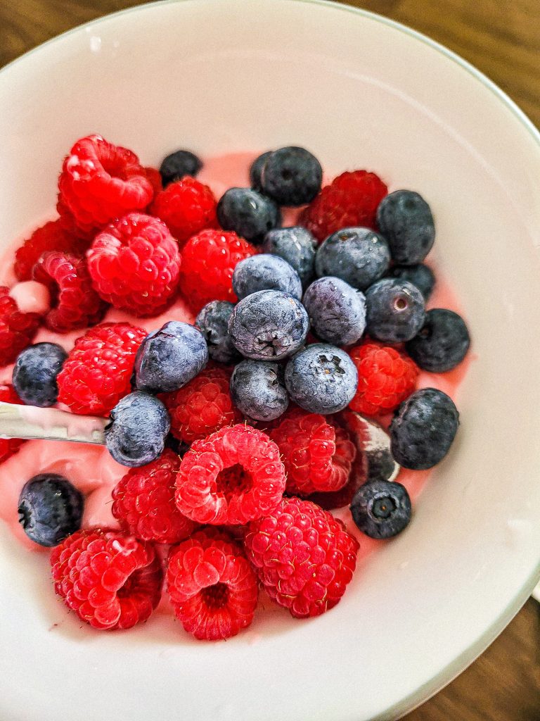 raspberry smoothie recipe with fruit on top in a bowl. 