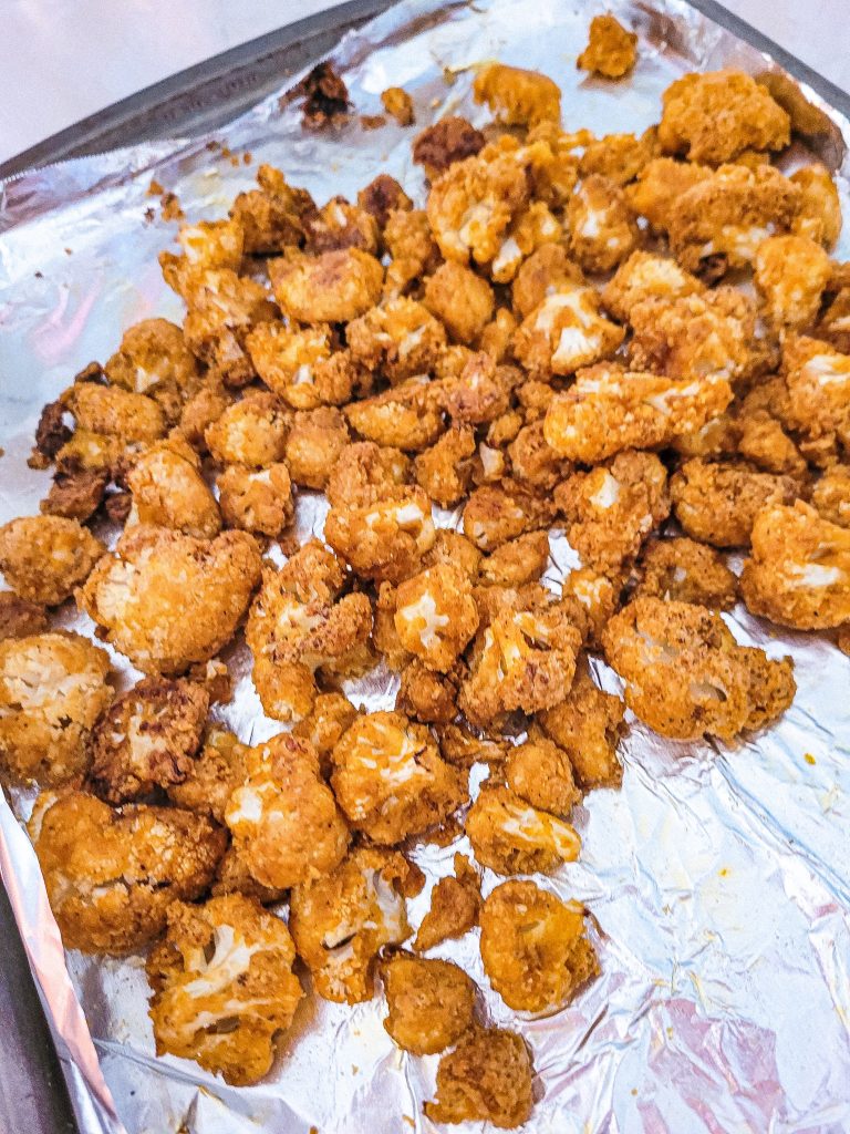 air fryer buffalo cauliflower on a sheet pan with aluminum foil.