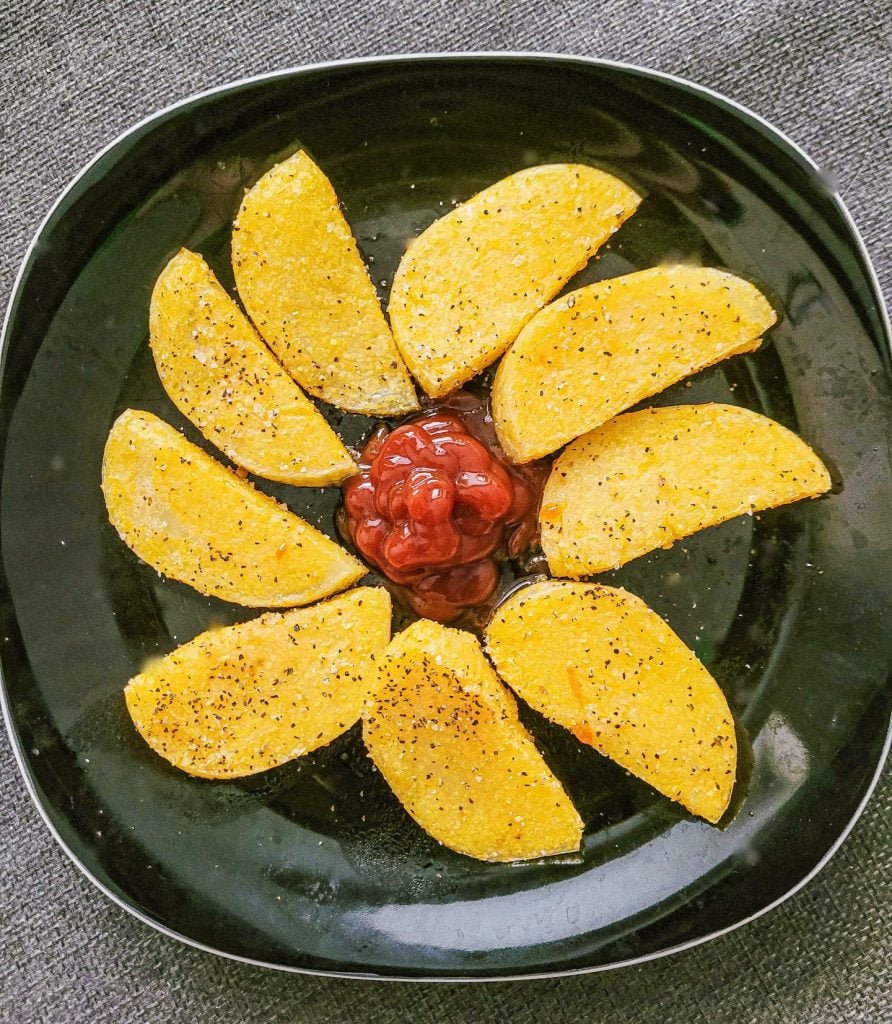 polenta fries on black plate.