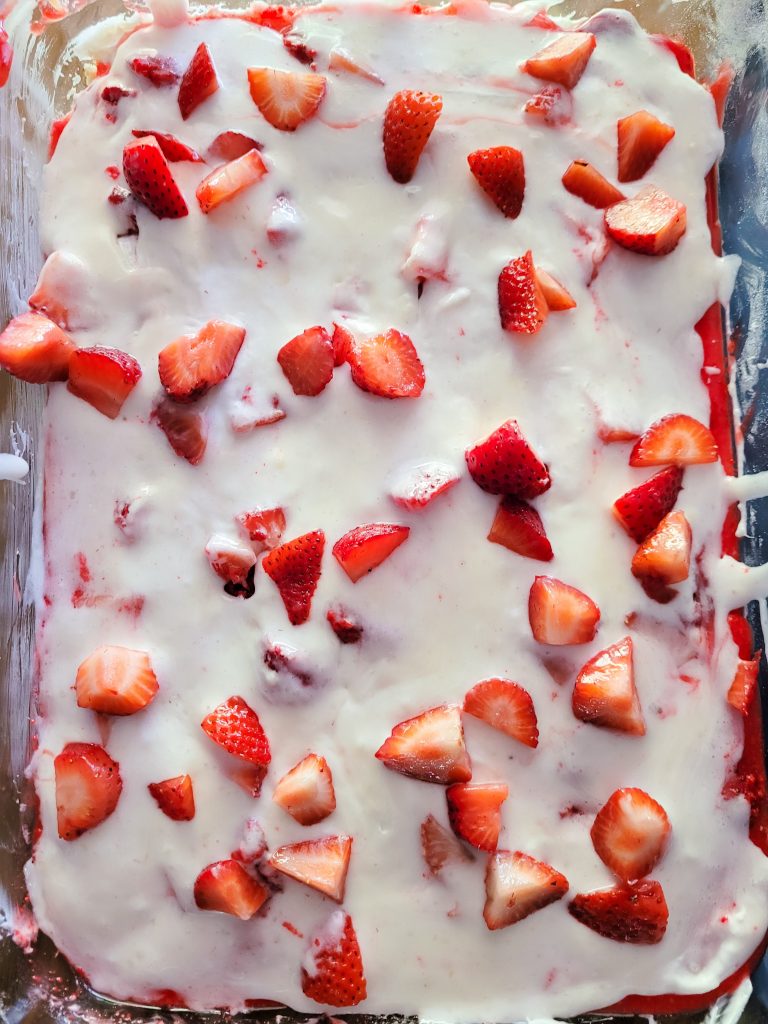 strawberry cheesecake lasagna top view in a glass pan.