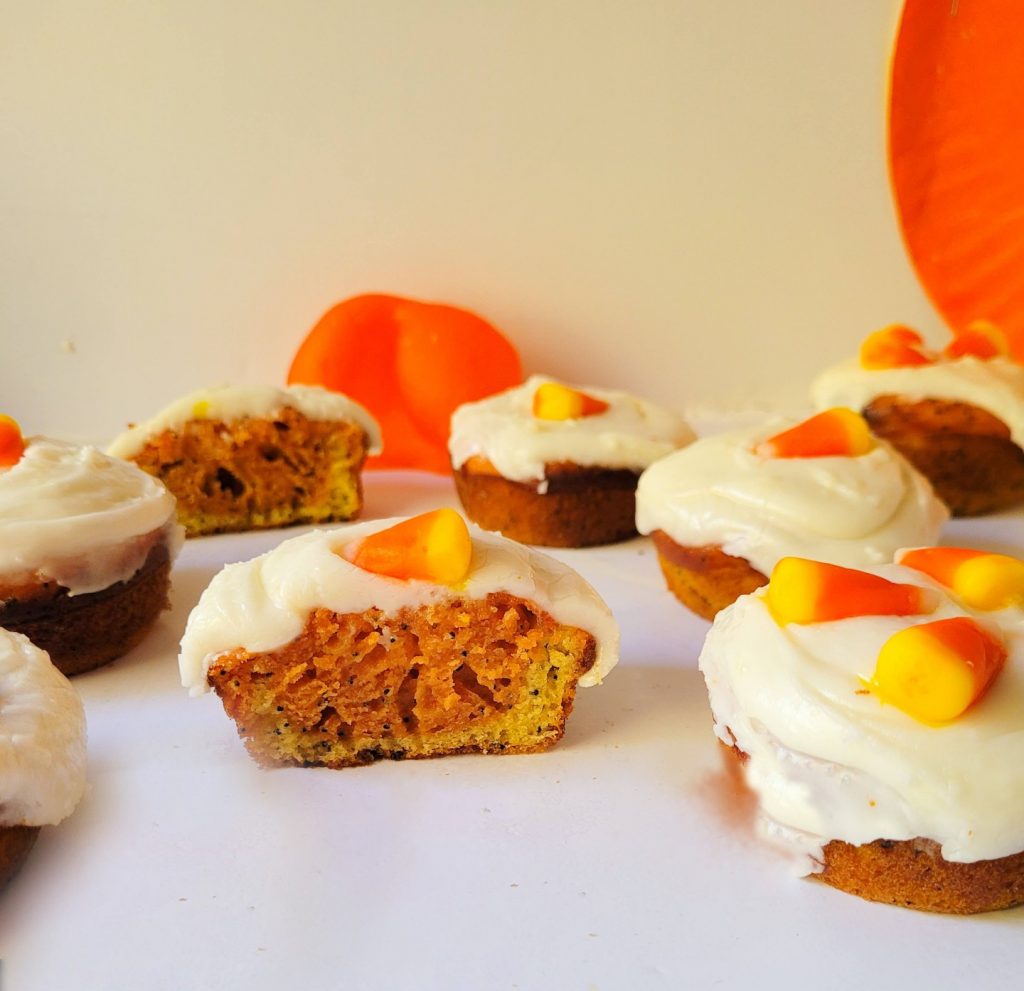 halloween candy corn cupcakes cut in half with a white background.