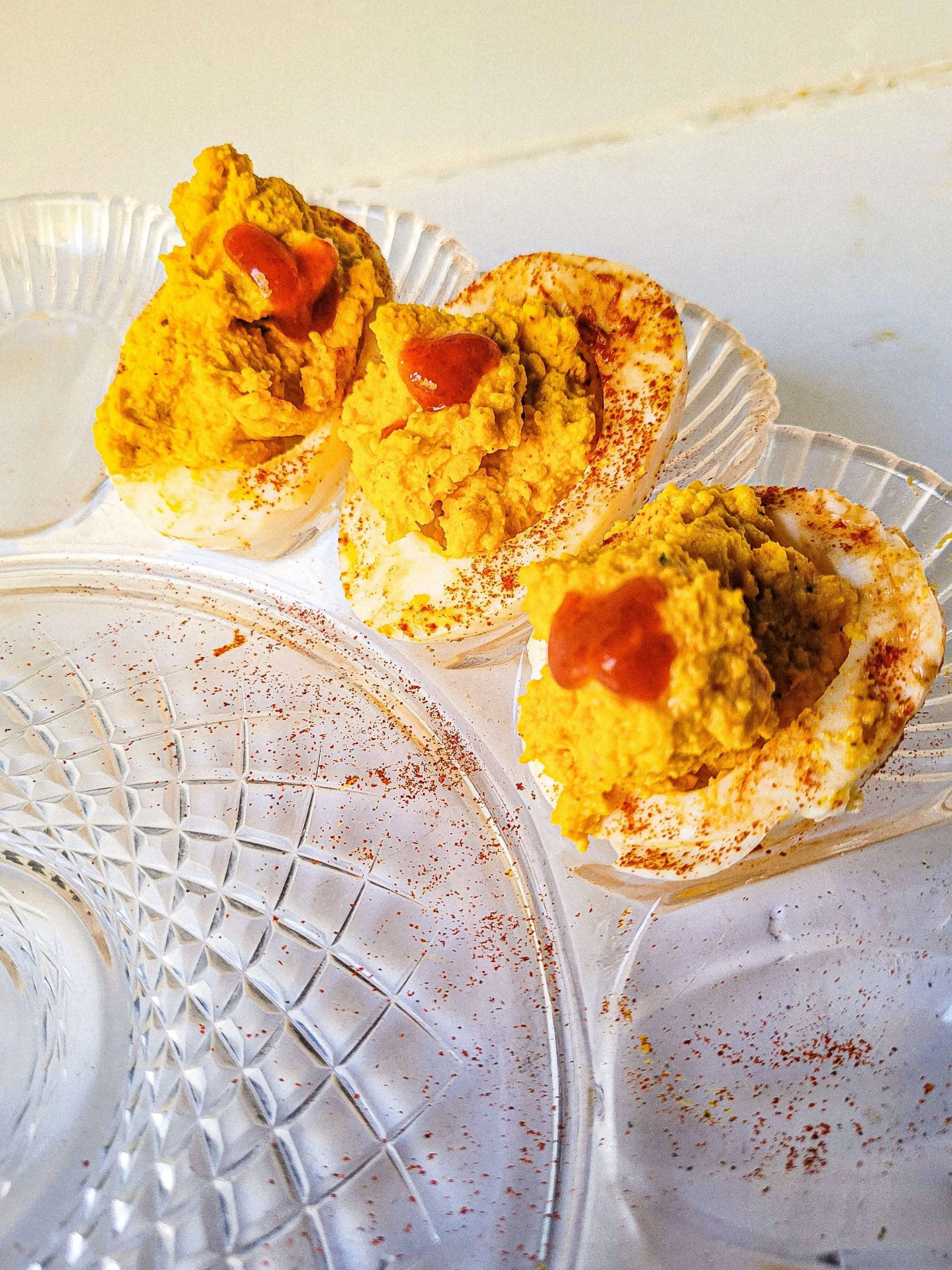 spicy deviled eggs recipe with paprika and hot sauce on top. 