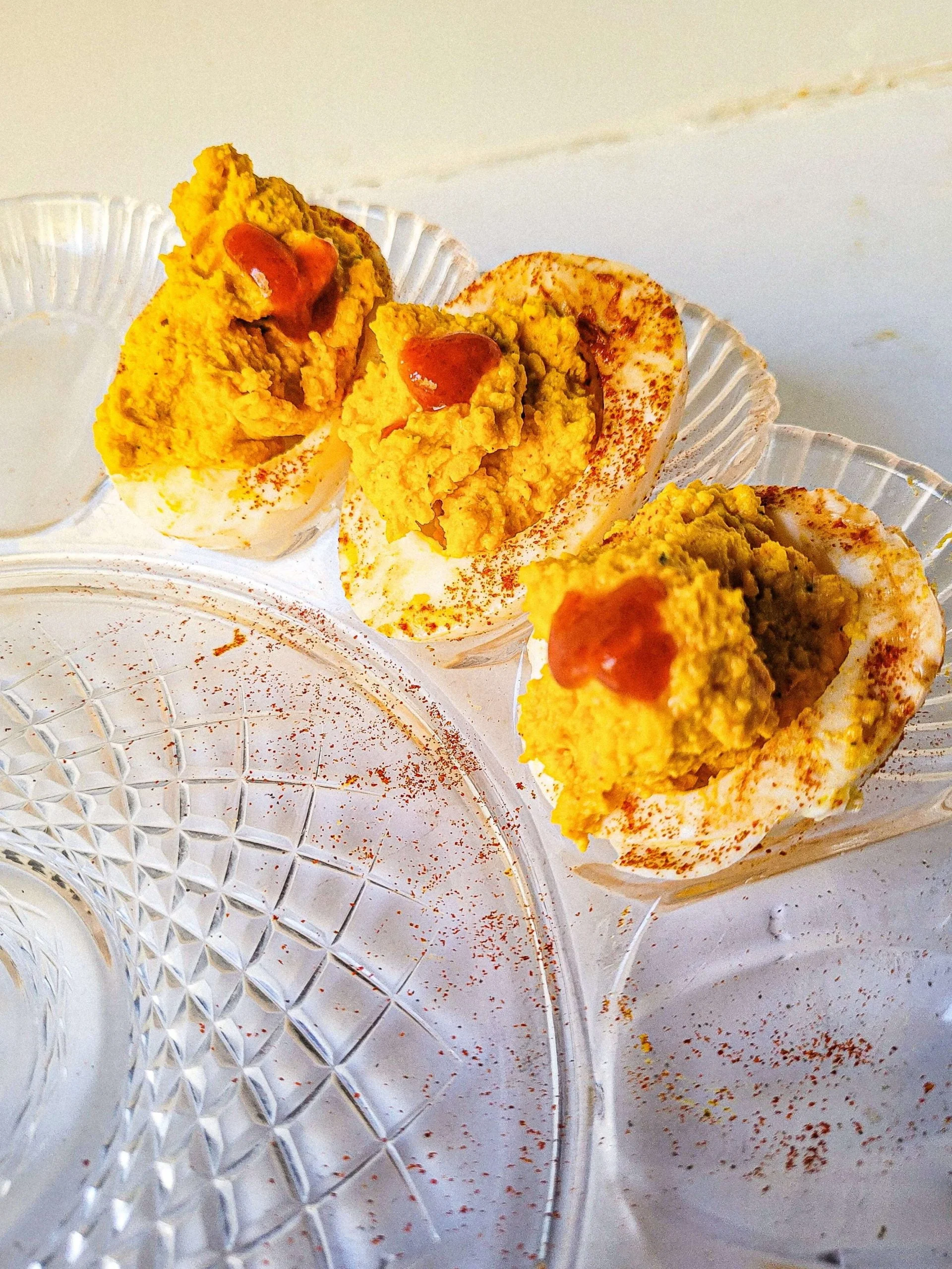 spicy deviled eggs recipe with paprika and hot sauce on top.