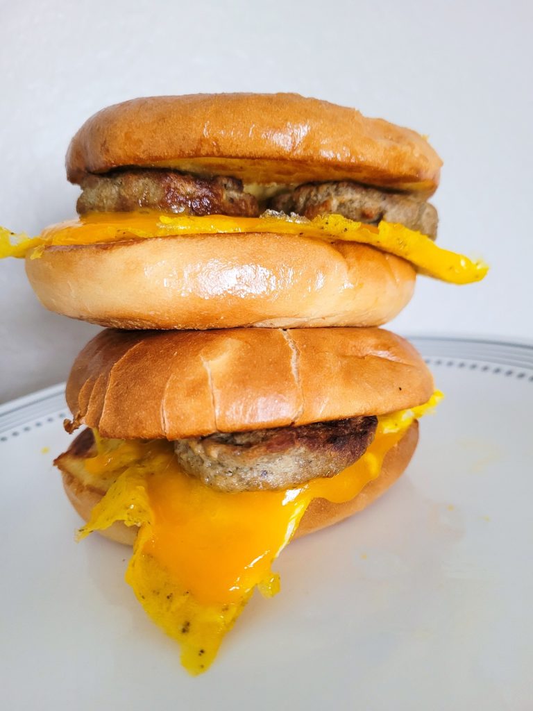 bagel breakfast sandwich stacked with a white background.