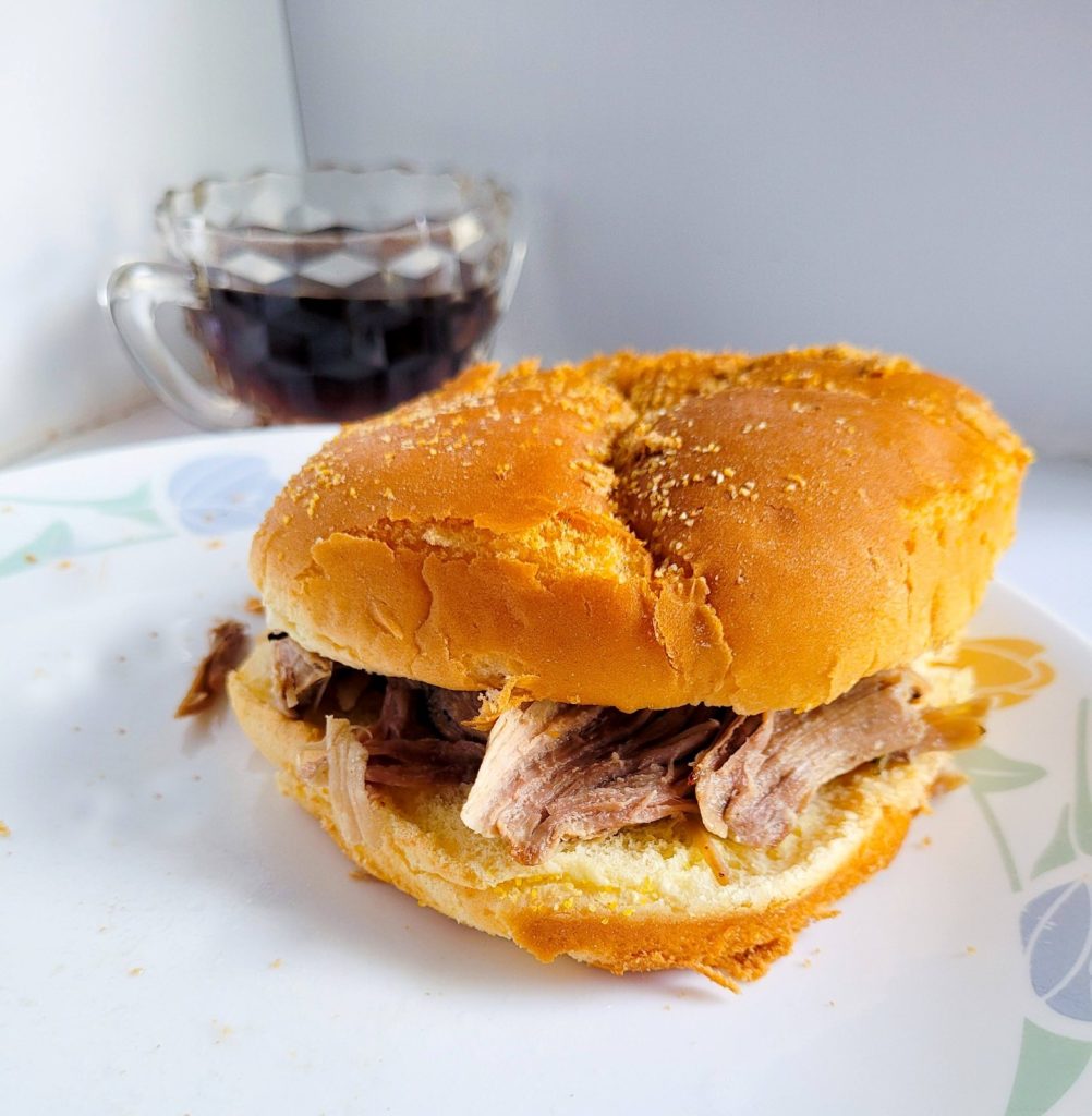 french dip sliders with au jus in the background. 