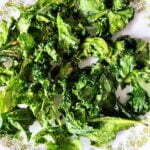 crispy air fryer kale chips on a white plate.