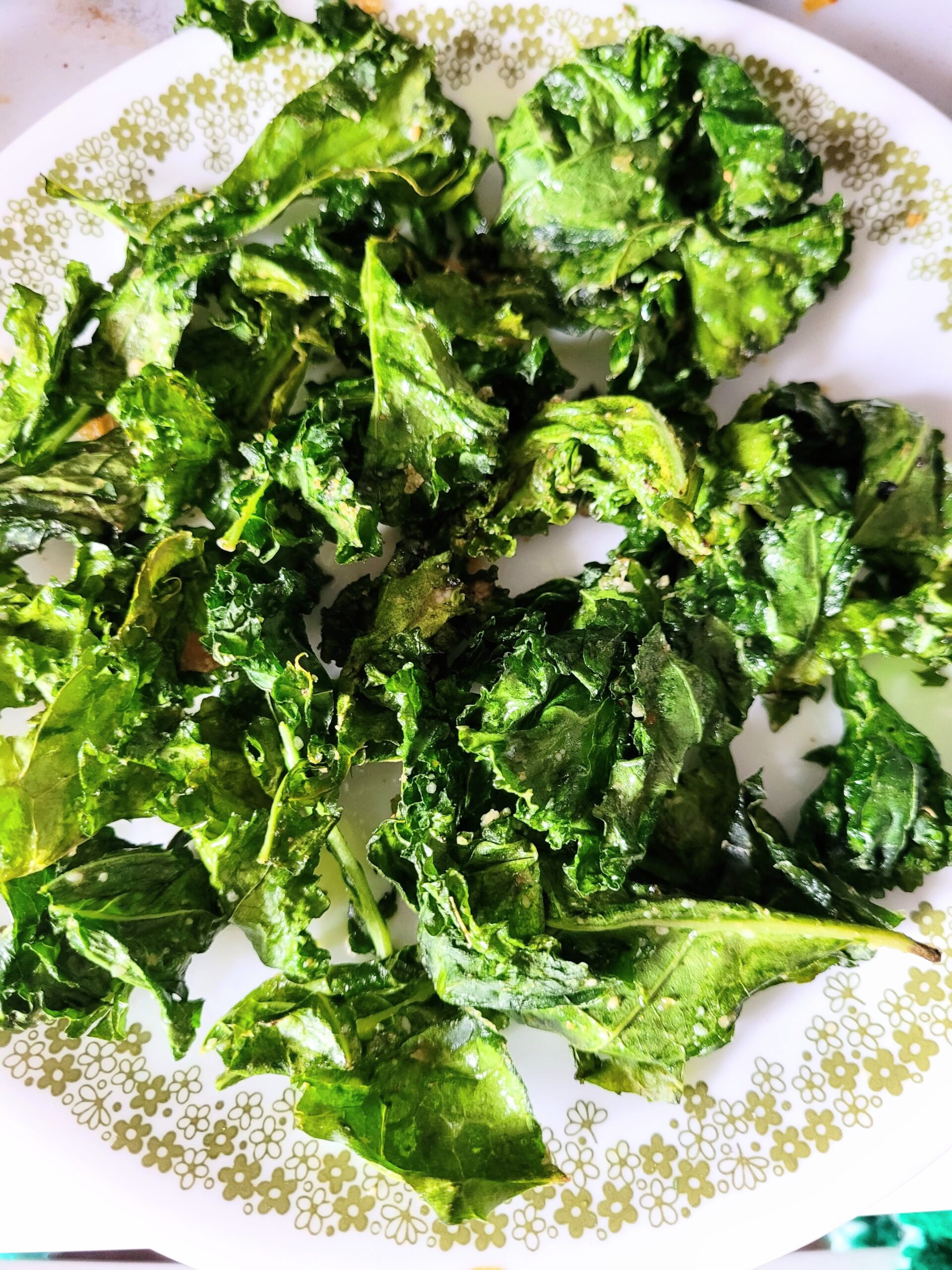 crispy air fryer kale chips on a white plate. 