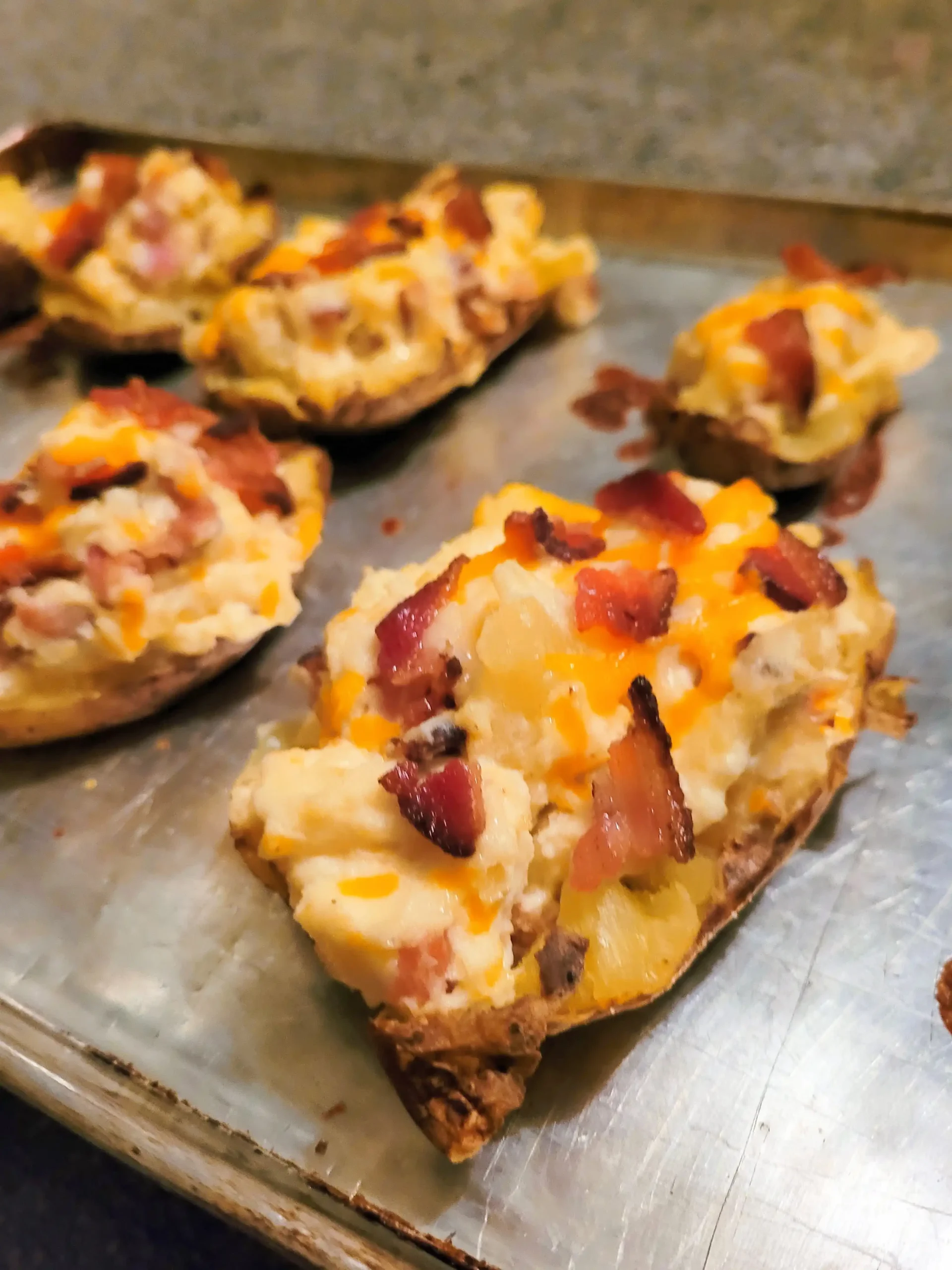 air fryer baked potato with cheese and bacon on top.