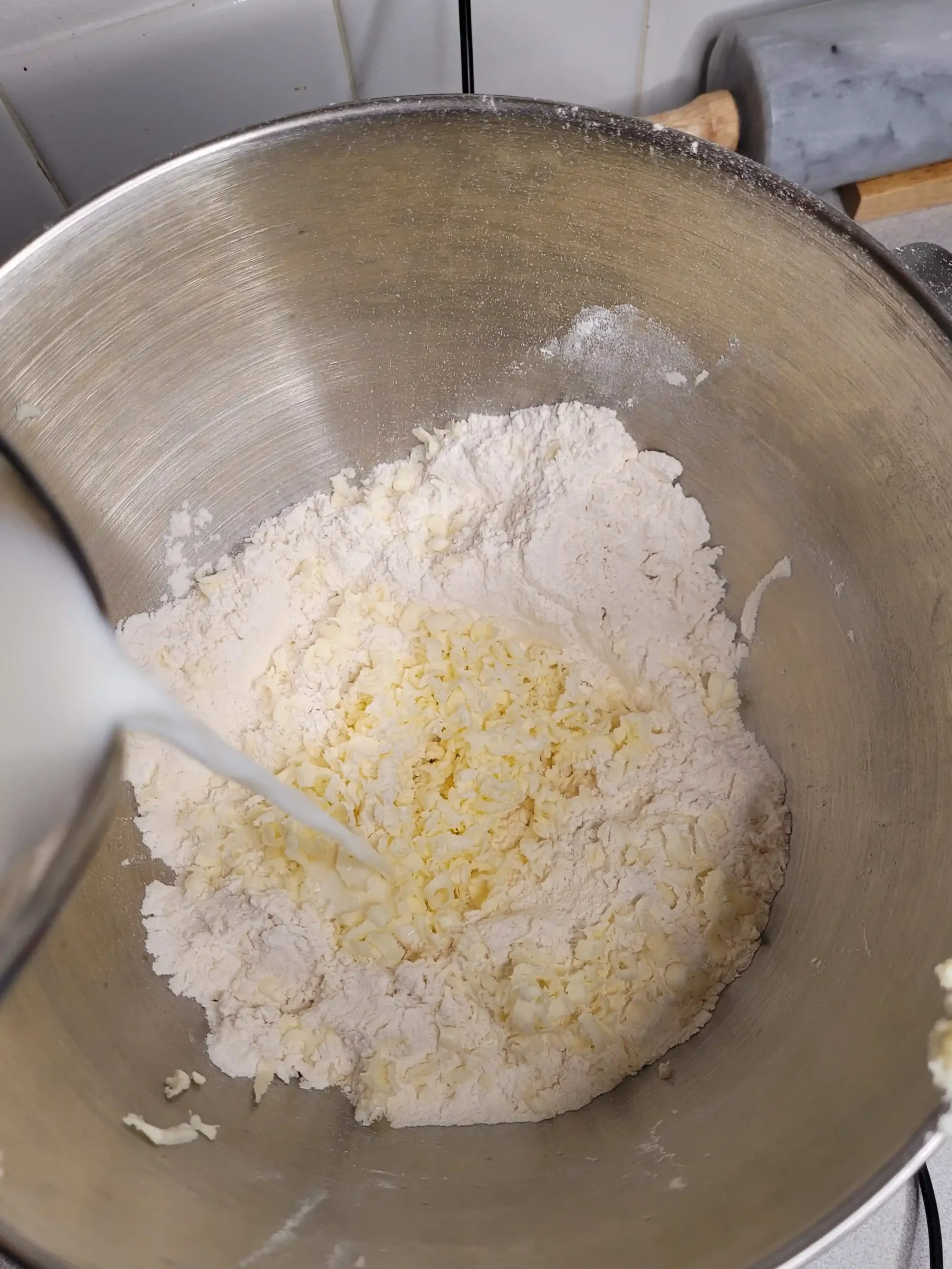 milk being poured into homemade biscuit dough.