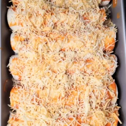 Prebaked buffalo chicken enchiladas with sauce and cheese on top.