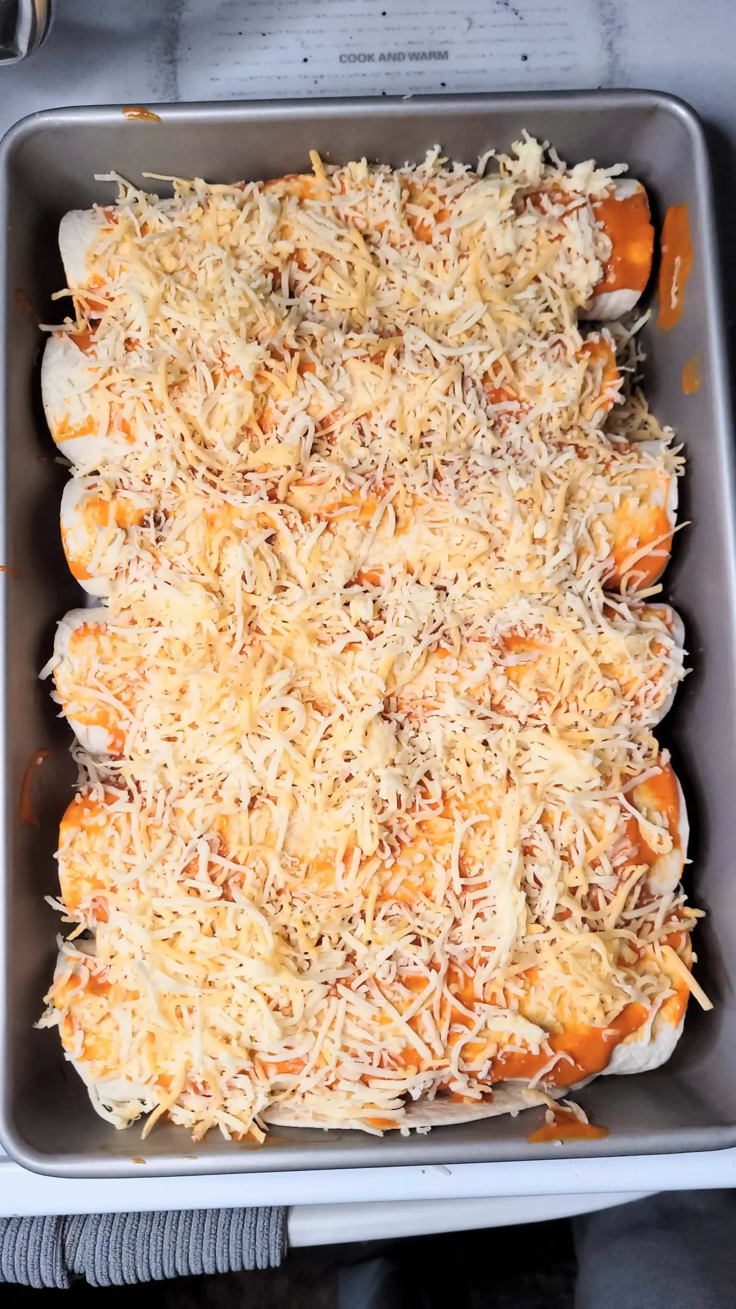 Prebaked buffalo chicken enchiladas with sauce and cheese on top.