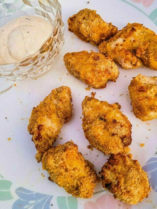 homemade chicken nuggets on plate with a cup of ranch dressing.