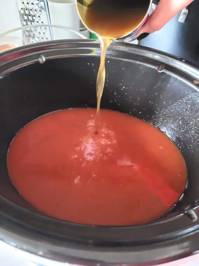 Broth being poured in crock pot.