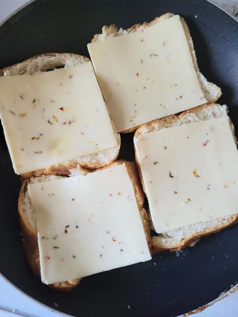 bread frying in pan with pepperjack cheese on top.