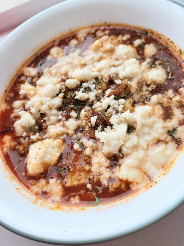 Close up of cheese on top of lasagna soup.