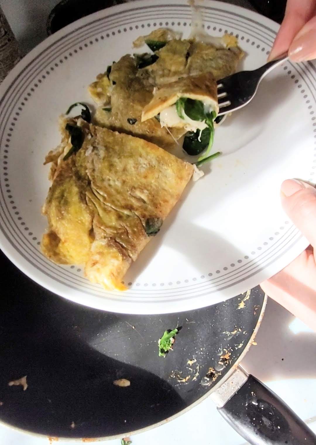 Cheese omlette on a plate with fork slicing a piece.