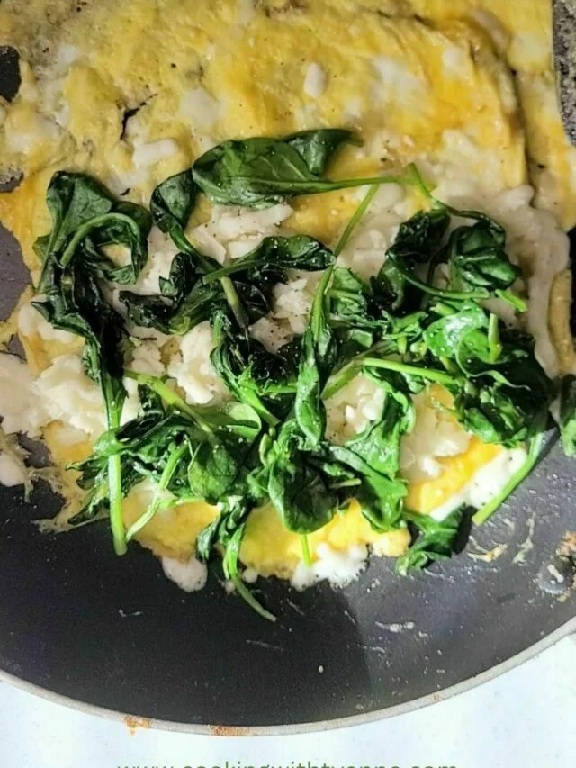 Spinach on omelet in skillet.