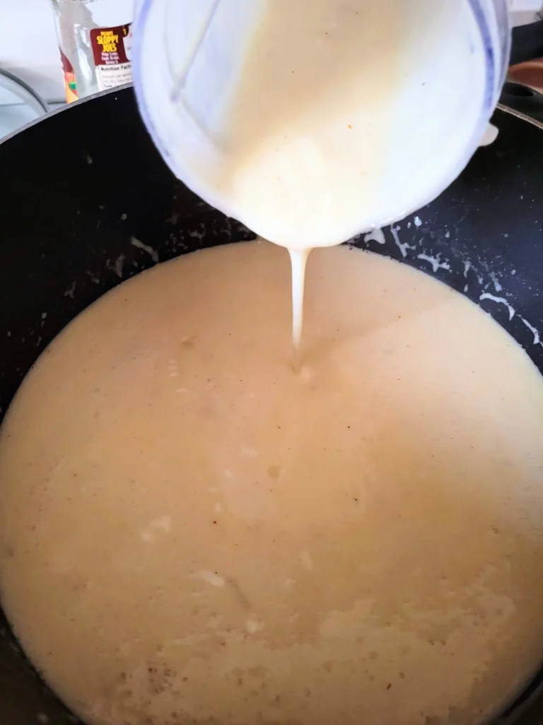 Blended soup being poured into pot.