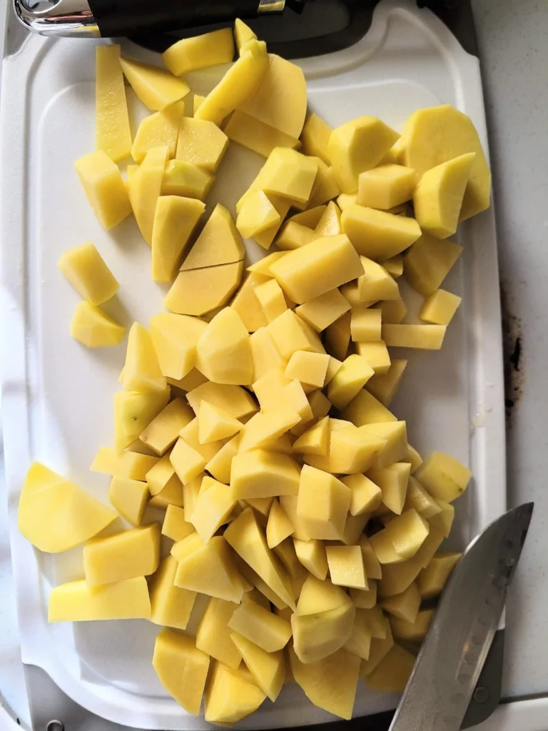 yellow potatoes cubed on a cutting board.