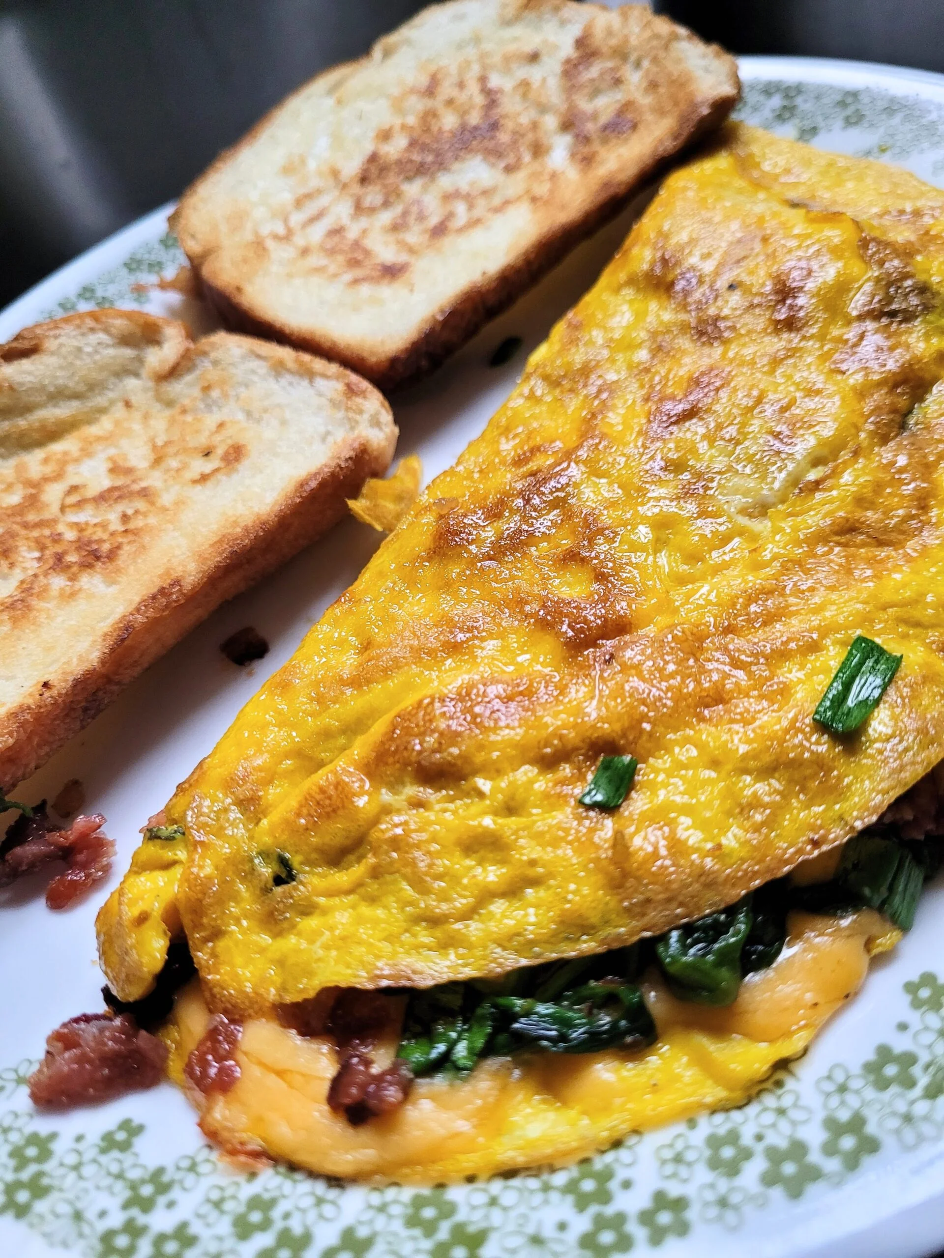 Spinach and cheese omelet with toast in the background.