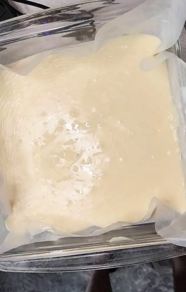 Vanilla fudge poured onto wax paper in pan.