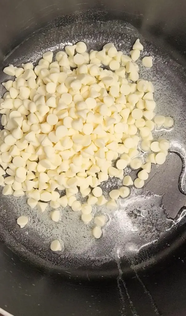 White chips melting in pot with butter.