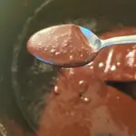 Hot fudge sauce on spoon.